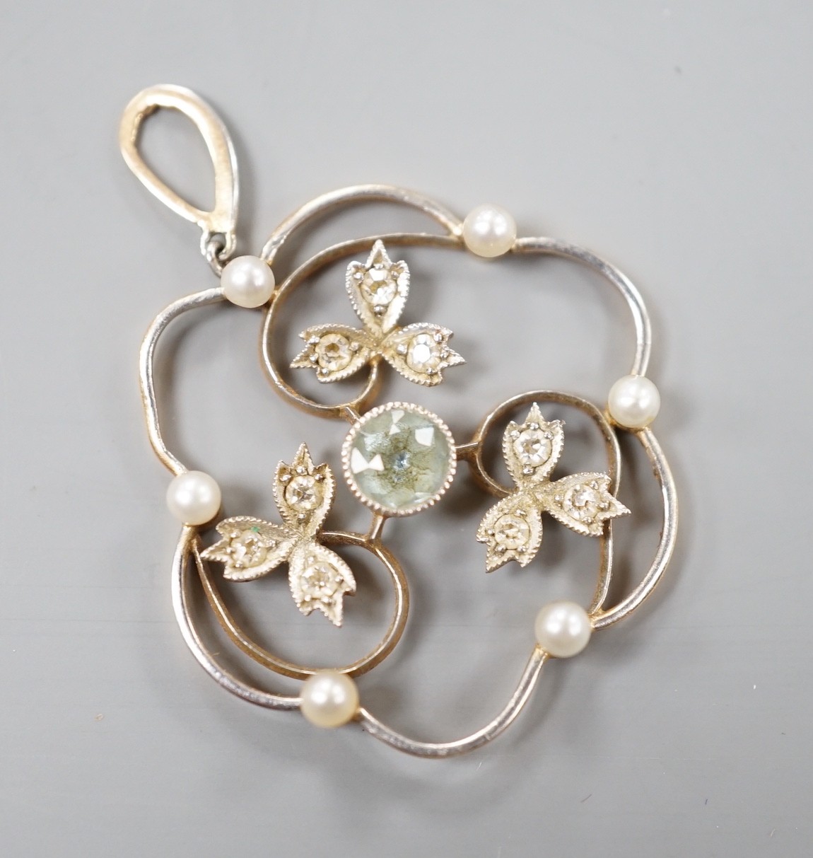 An Edwardian yellow metal, aquamarine, seed pearl and diamond chip set circular pendant, overall 34mm, gross weight 3.2 grams.